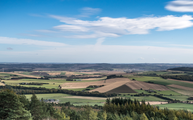 View looking east> </img>
><figcaption class=mycap>As you rise above the treelike, you get open views to the east over farmland to the coast. The unusual triangular fields here give the impression of a pyramid in the landscape. </figcaption></figure>
<figure> <img class=myimg horiz src= 